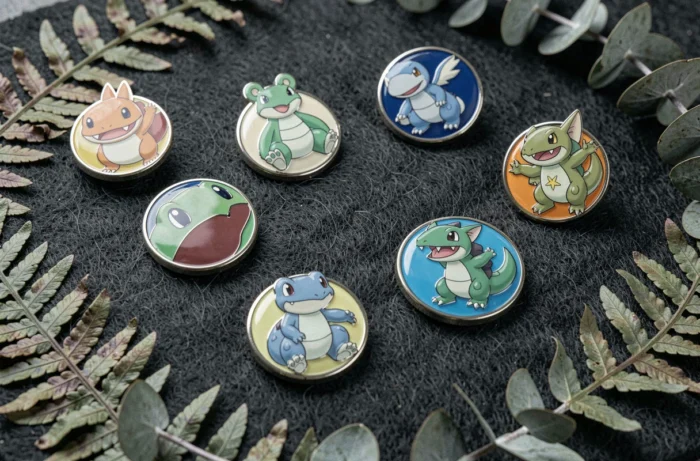 Gros plan de badges en émail Pokémon montés sur feutre avec décoration botanique pour un style éditorial